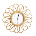 Round wall clock with a single rosette of rattan loops, 16.9 in. Battery operated.