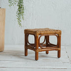 Square footstool with a hand woven rattan top on a dark wood frame