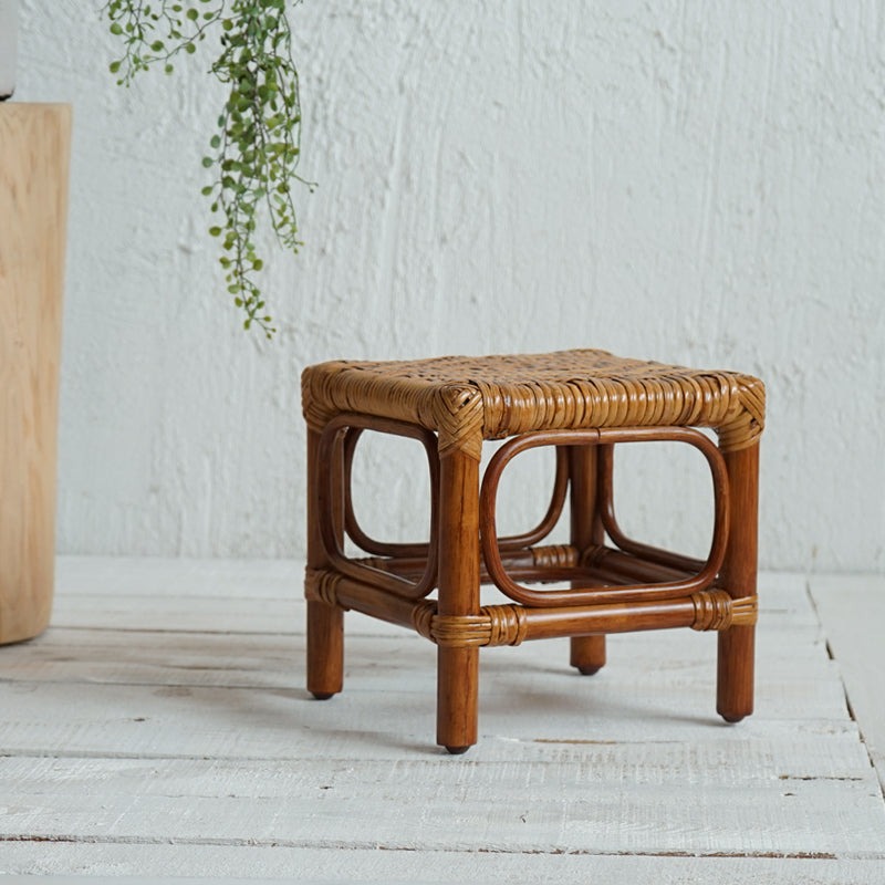 Square footstool with a hand woven rattan top on a dark wood frame