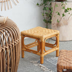 Square footstool with a hand woven rattan top on a light wood frame