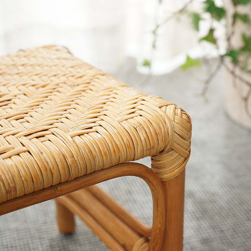Square footstool with a hand woven rattan top on a light wood frame