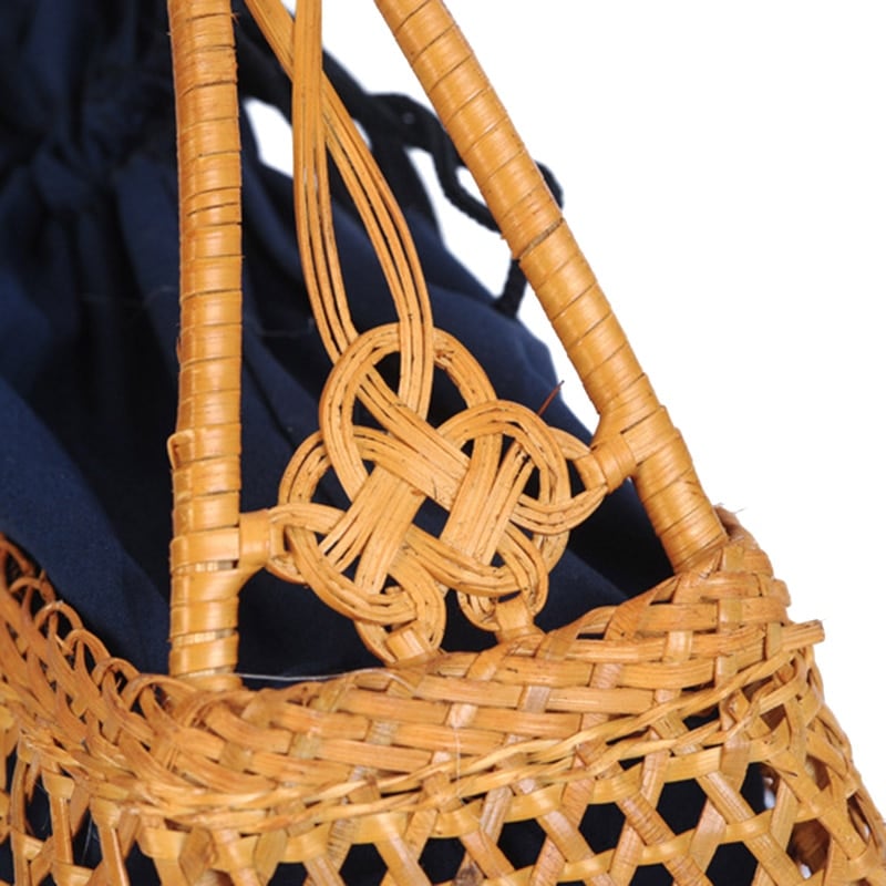 Honey toned hand woven rattan handbag with varnished wooden handles and a drawstring