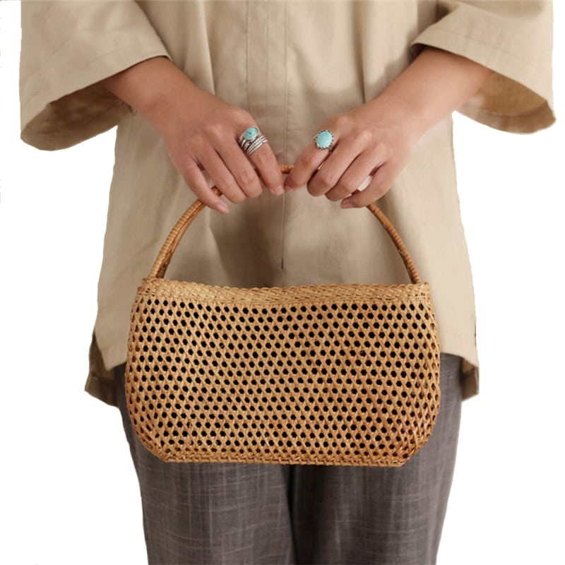 Honey toned hand woven rattan handbag with varnished wooden handles and a drawstring