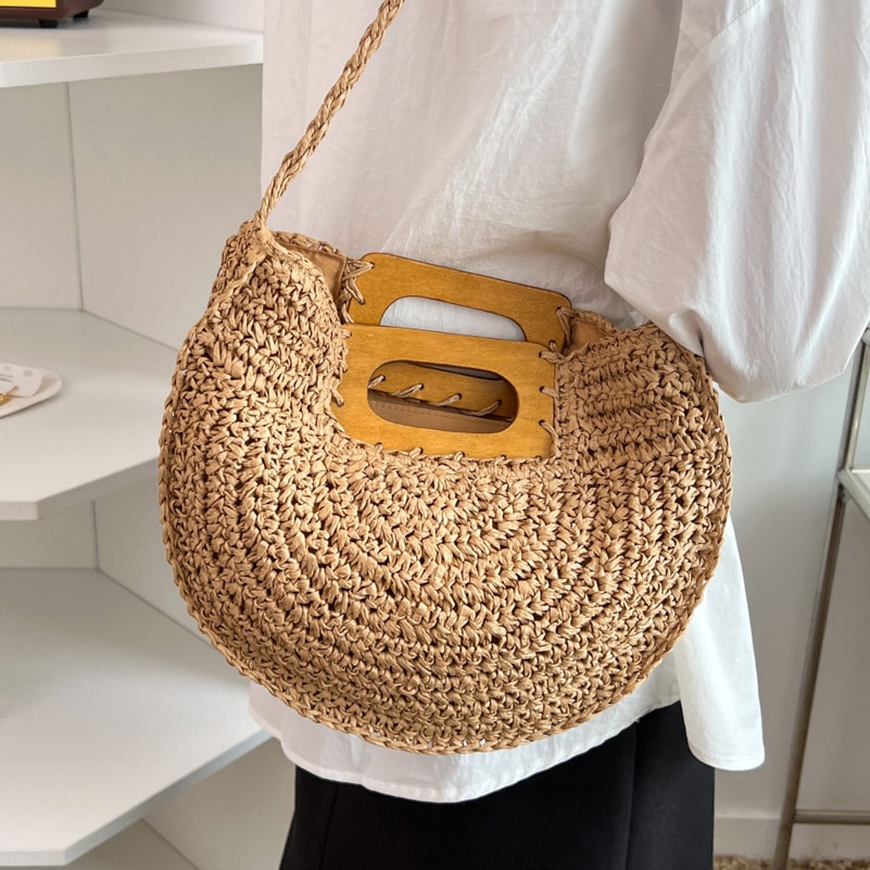 Rounded hand woven rattan handbag with a natural wooden handle