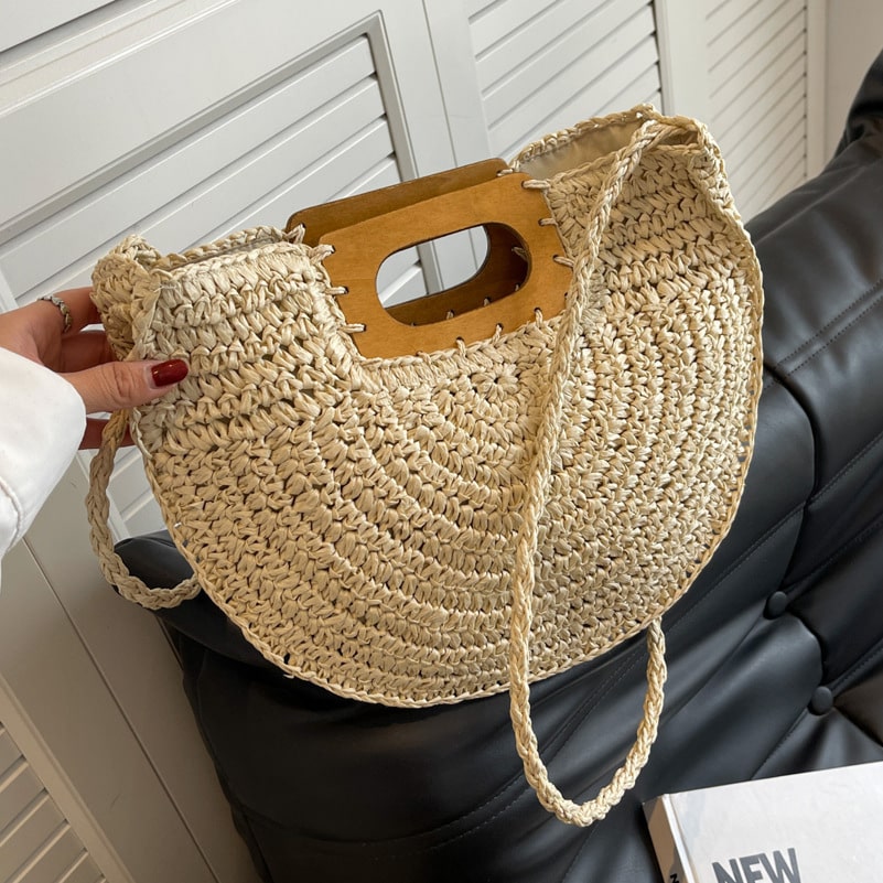 Rounded hand woven rattan handbag with a natural wooden handle