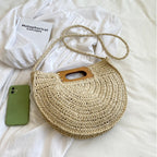 Rounded hand woven rattan handbag with a natural wooden handle