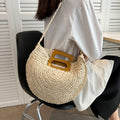 Rounded hand woven rattan handbag with a natural wooden handle