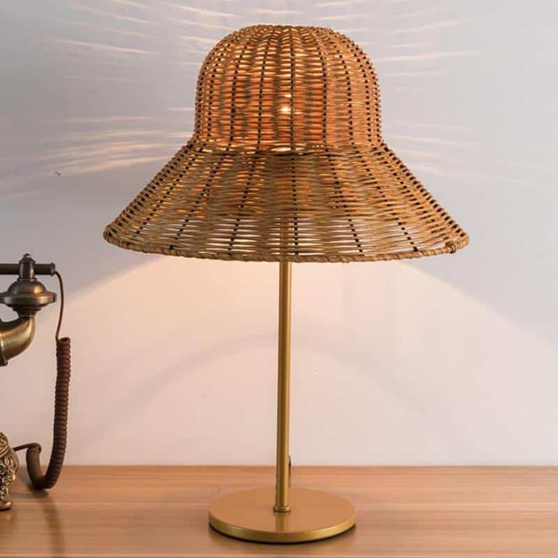 Table lamp with a wide hand woven rattan hat shaped shade and woven base