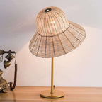 Table lamp with a wide hand woven rattan hat shaped shade and woven base
