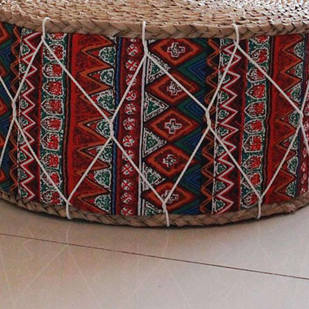 Round hand woven rattan pouf with red and blue geometric patterns