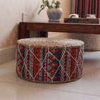 Round hand woven rattan pouf with red and blue geometric patterns