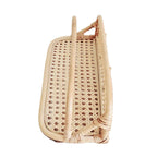 Hand woven rattan wall rack with metal coat hooks in a warm beige