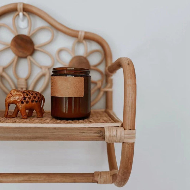 Natural rattan wall coat rack with a hanging rail and a hand woven floral top shelf