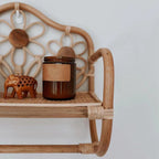 Natural rattan wall coat rack with a hanging rail and a hand woven floral top shelf