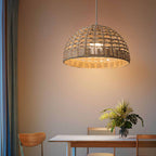 Handwoven rattan and wicker dome lamp shade hung over a table