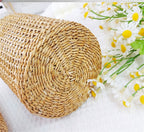 Glass bottle vase wrapped in woven rattan holding poppies