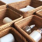 Rectangular honey rattan baskets holding bathroom products