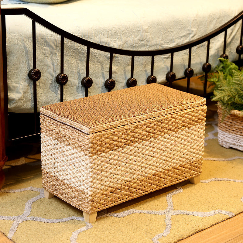 Rectangular hand woven rattan storage stool with a lift off lid on wood feet