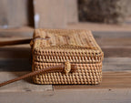 Compact rectangular hand woven rattan crossbody pouch with clean edges