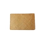 Rectangular hand woven golden seagrass placemat with a ribbed texture