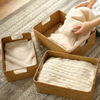 Rectangular woven shelf baskets holding folded clothes