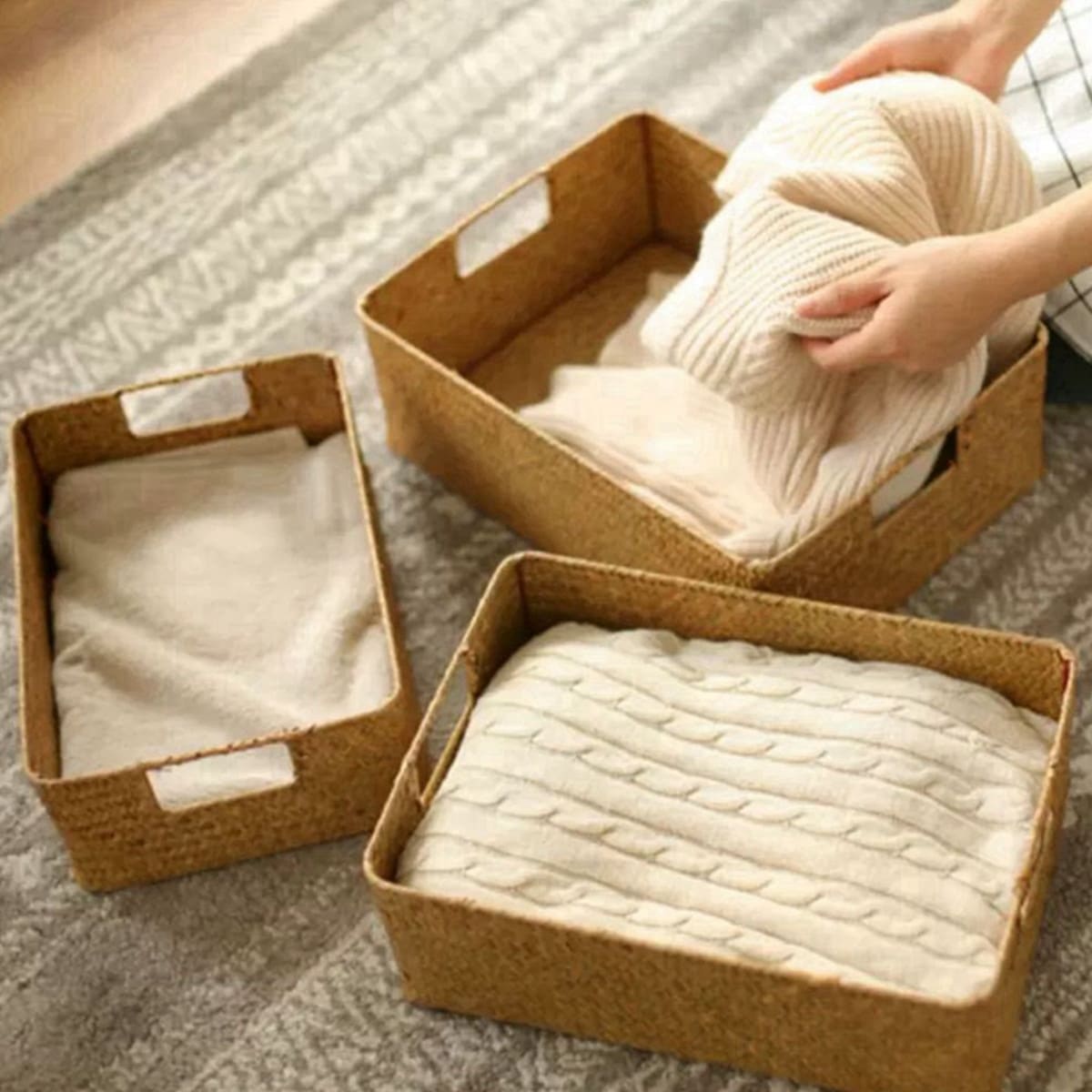 Rectangular woven shelf baskets holding folded clothes