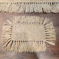 Rectangular hand woven beige straw placemat with fine fringed edges