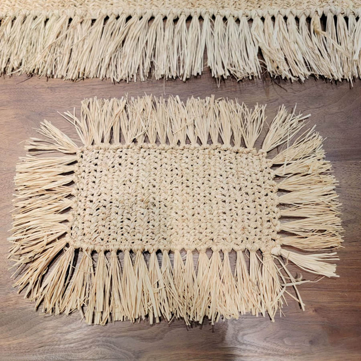 Rectangular hand woven beige straw placemat with fine fringed edges