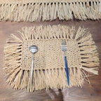 Rectangular hand woven beige straw placemat with fine fringed edges