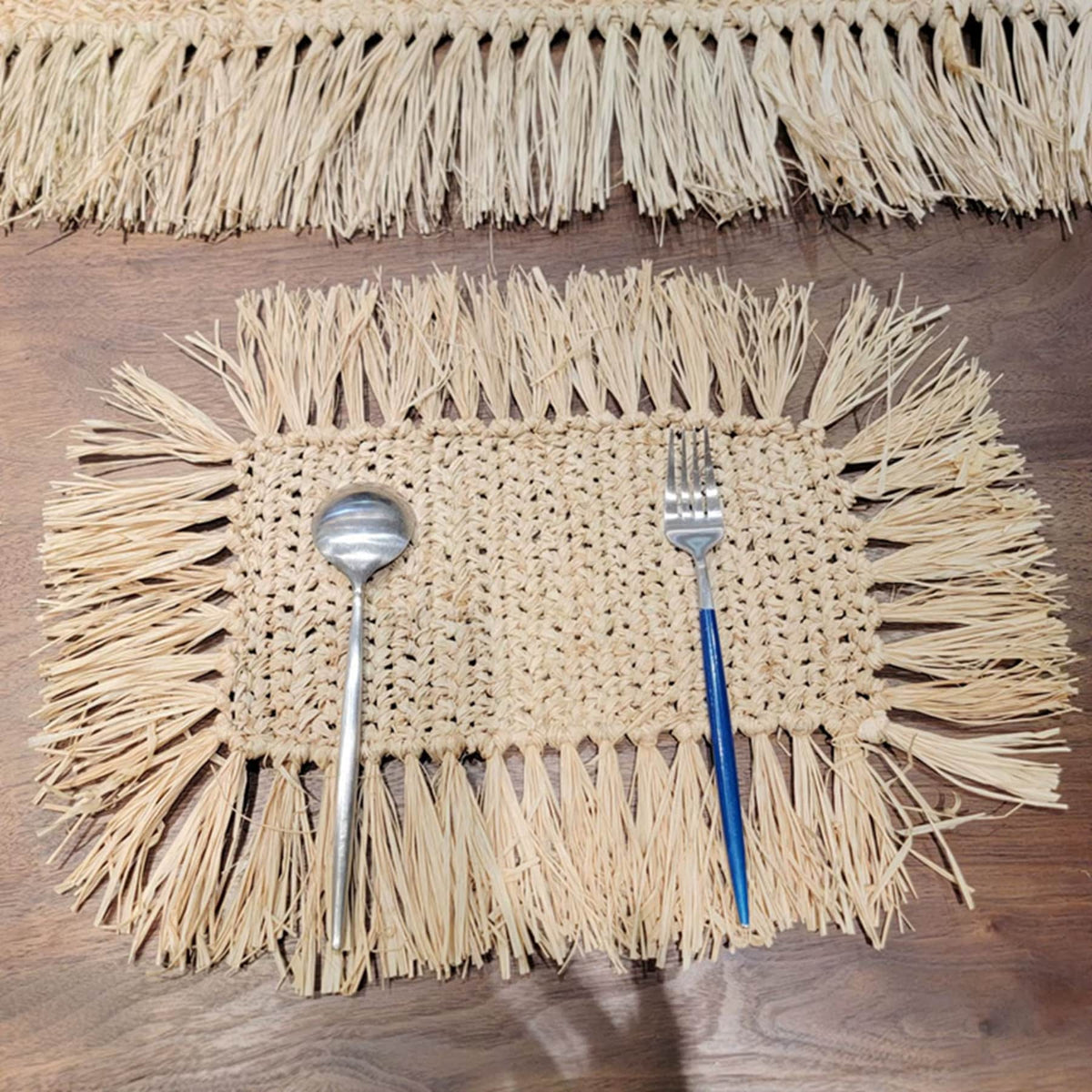 Rectangular hand woven beige straw placemat with fine fringed edges