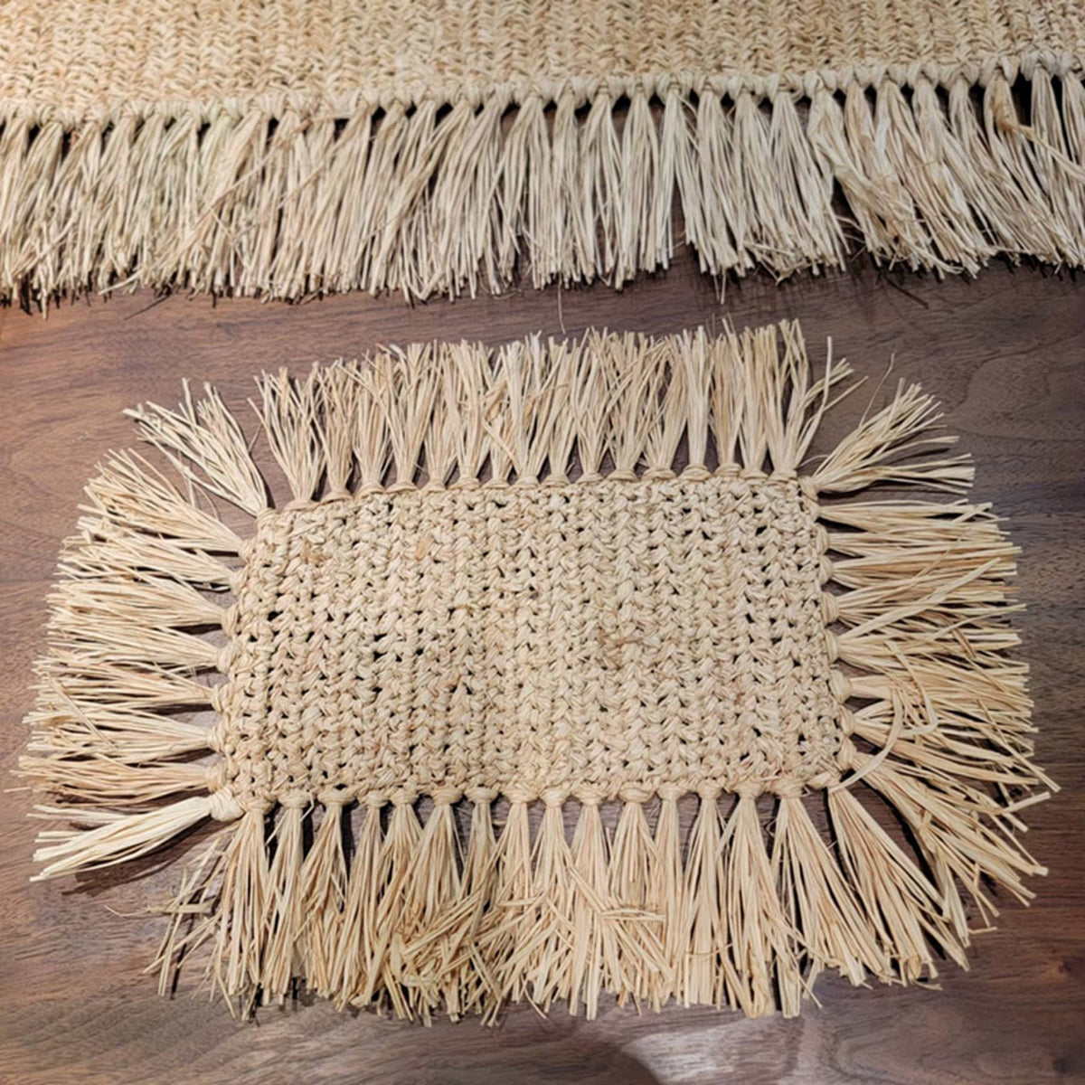 Rectangular hand woven beige straw placemat with fine fringed edges