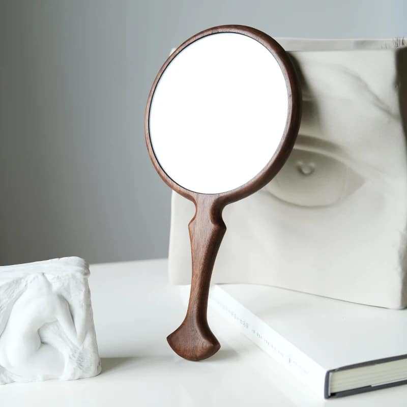Round dark wooden hand mirror with curved handle