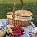 Retro wicker picnic basket with double lid and lace liner on a picnic blanket