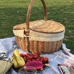 Retro wicker picnic basket with double lid and lace liner on a picnic blanket
