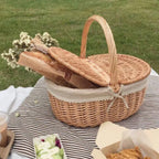 Retro wicker picnic basket with double lid and lace liner on a picnic blanket