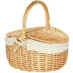 Retro wicker picnic basket with double lid and lace liner on a picnic blanket