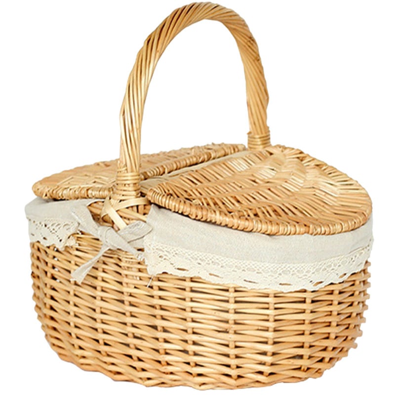 Retro wicker picnic basket with double lid and lace liner on a picnic blanket