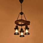 Retro chandelier made of natural wood branches on a dark iron frame with glass
