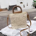 Rounded retro woven straw bag with a varnished wooden handle and shoulder strap