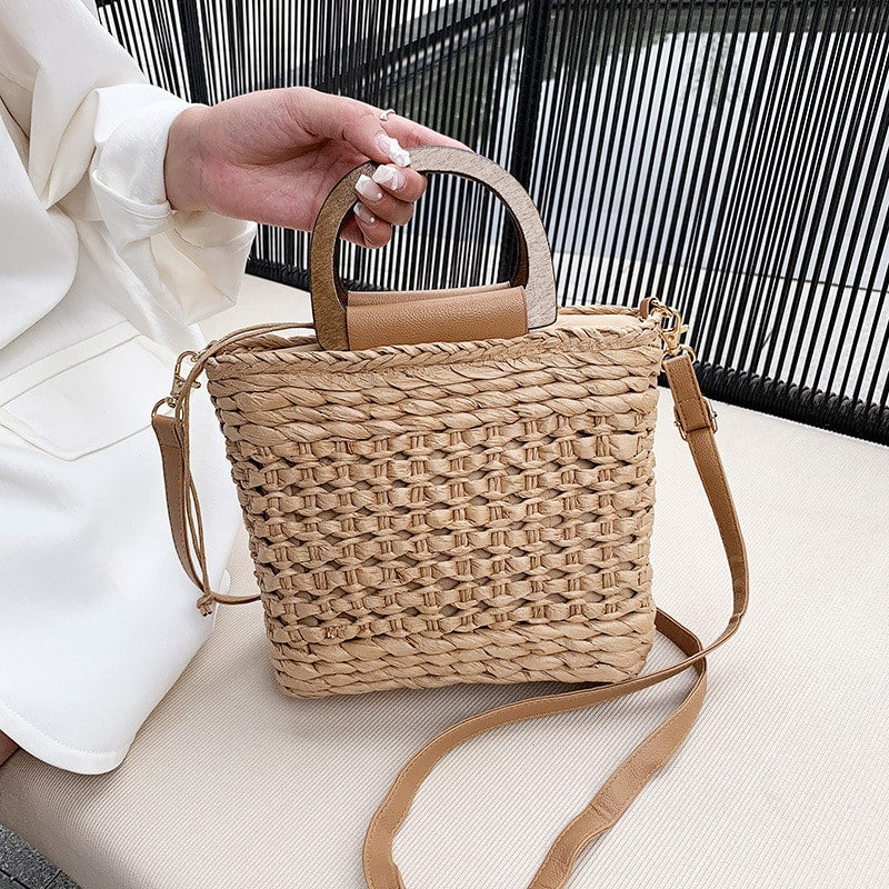Rounded retro woven straw bag with a varnished wooden handle and shoulder strap