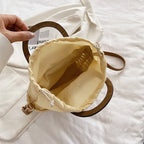 Rounded retro woven straw bag with a varnished wooden handle and shoulder strap