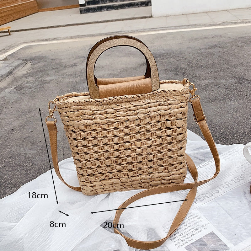 Rounded retro woven straw bag with a varnished wooden handle and shoulder strap