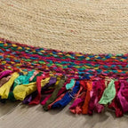 Round jute rug with a multicolor braided center and fabric fringe