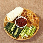 Round bamboo serving plate with five sections around a center well