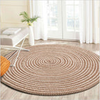 Round brown and white braided rug in a bright room