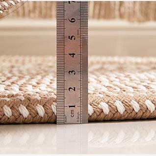 Round brown and white braided rug in a bright room