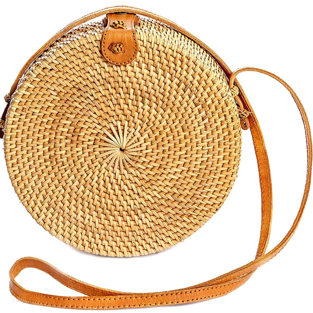 Round structured brown rattan crossbody bag with an adjustable shoulder strap