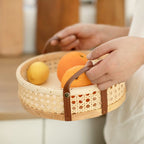 Round low cane webbing basket with leather handles in beige
