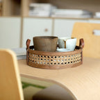 Round low cane webbing basket with leather handles in brown