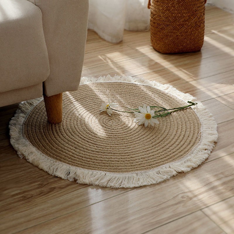 Round woven cotton and linen rug with a cream fringe